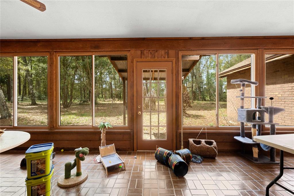 17055 Sweetwater Road Dade City, FL 33523 - Photo 39 of 53 a living room filled with furniture and floor to ceiling windows