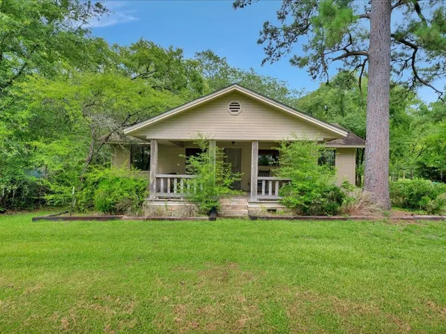 a front view of a house with a yard and trees