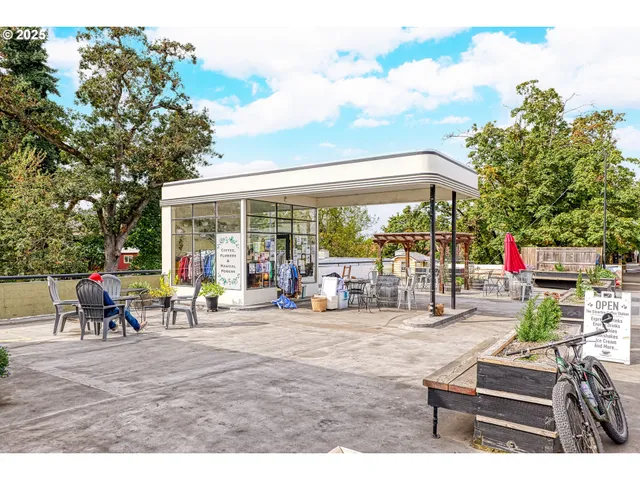a view of a patio with table and chairs potted plants and floor to ceiling window