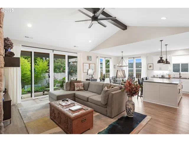 a living room with furniture and a large window with garden view