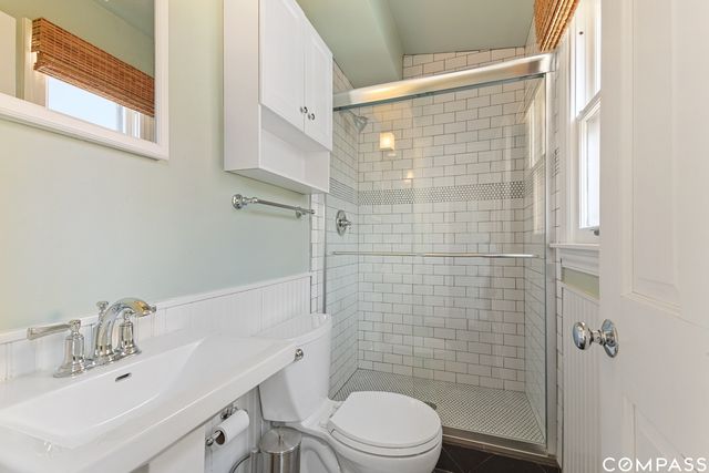 a bathroom with a sink a toilet and shower