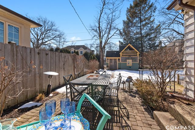 a view of a chairs and table in backyard
