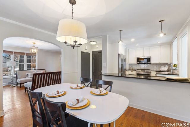 a view of a dining room with furniture wooden floor and chandelier