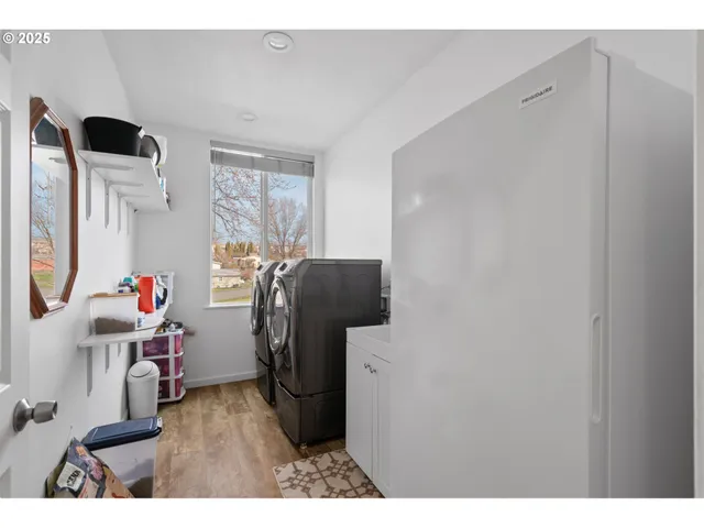 a utility room with wooden floor washer and dryer