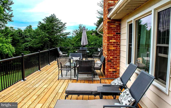 a balcony with wooden floor table and chairs