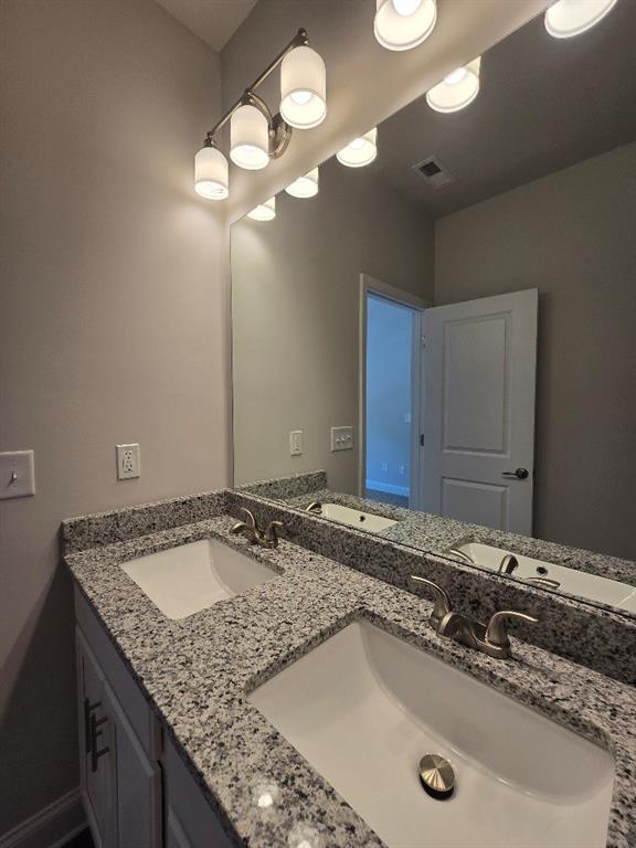 6194 Ripple Way, Unit 86 Atlanta, GA 30349 - Photo 14 of 27 a bathroom with a granite countertop sink and a mirror