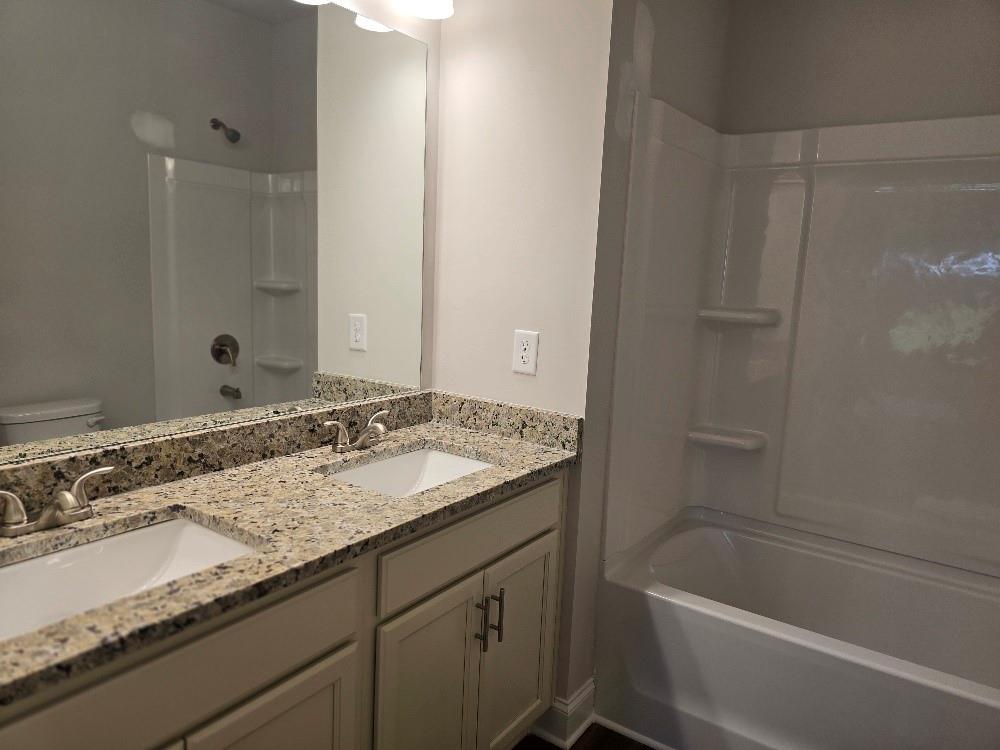 6194 Ripple Way, Unit 86 Atlanta, GA 30349 - Photo 20 of 27 a bathroom with a granite countertop sink and a mirror