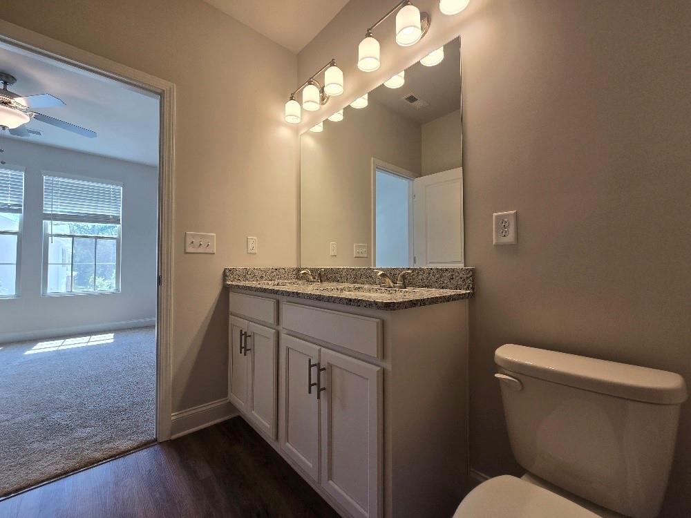 6194 Ripple Way, Unit 86 Atlanta, GA 30349 - Photo 21 of 27 a bathroom with a toilet a sink and a mirror