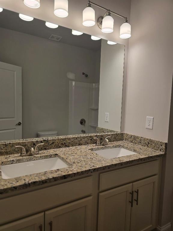 6194 Ripple Way, Unit 86 Atlanta, GA 30349 - Photo 26 of 27 a bathroom with a granite countertop sink and a mirror