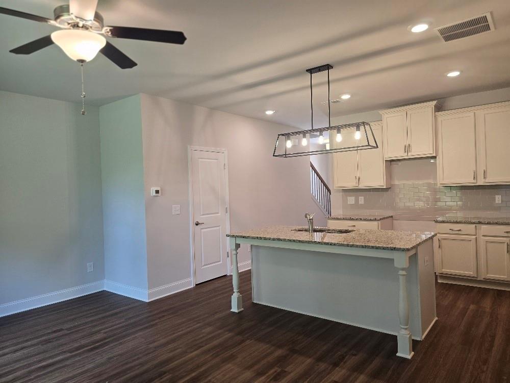 6194 Ripple Way, Unit 86 Atlanta, GA 30349 - Photo 9 of 27 a kitchen with kitchen island stainless steel appliances a chandelier and wooden floor