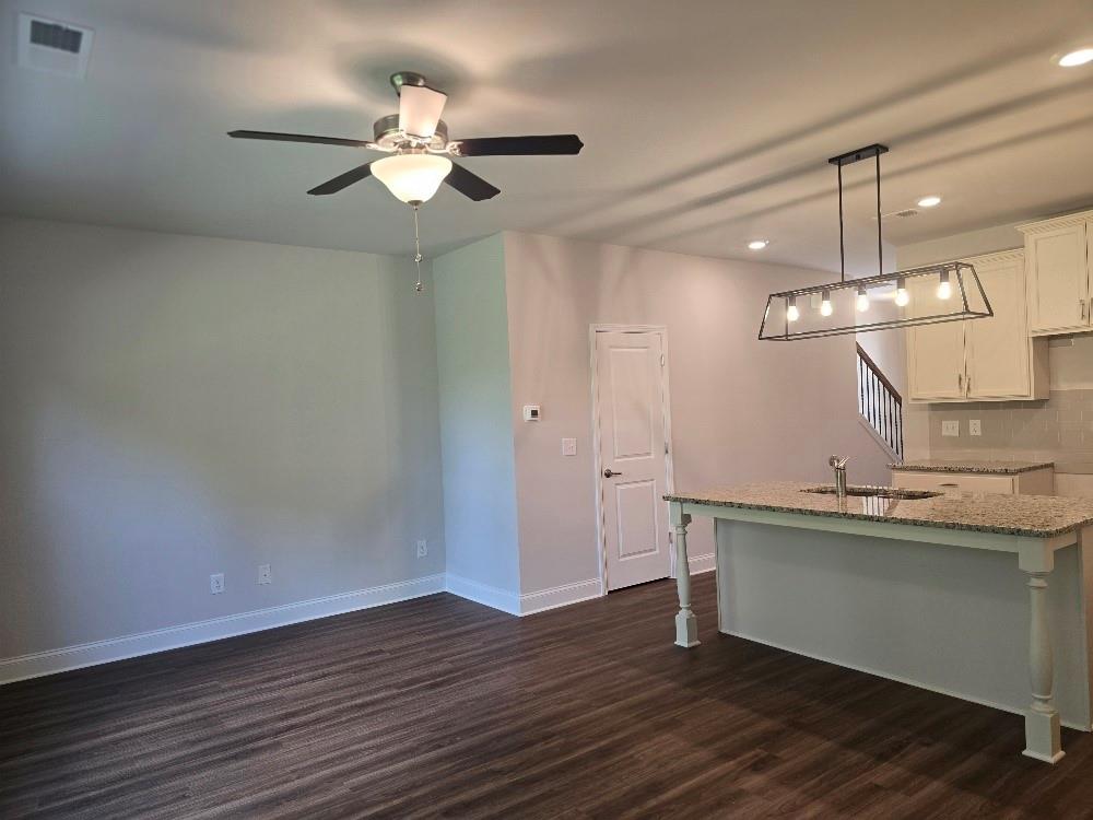 6194 Ripple Way, Unit 86 Atlanta, GA 30349 - Photo 10 of 27 a view of a room with a chandelier fan and wooden floor