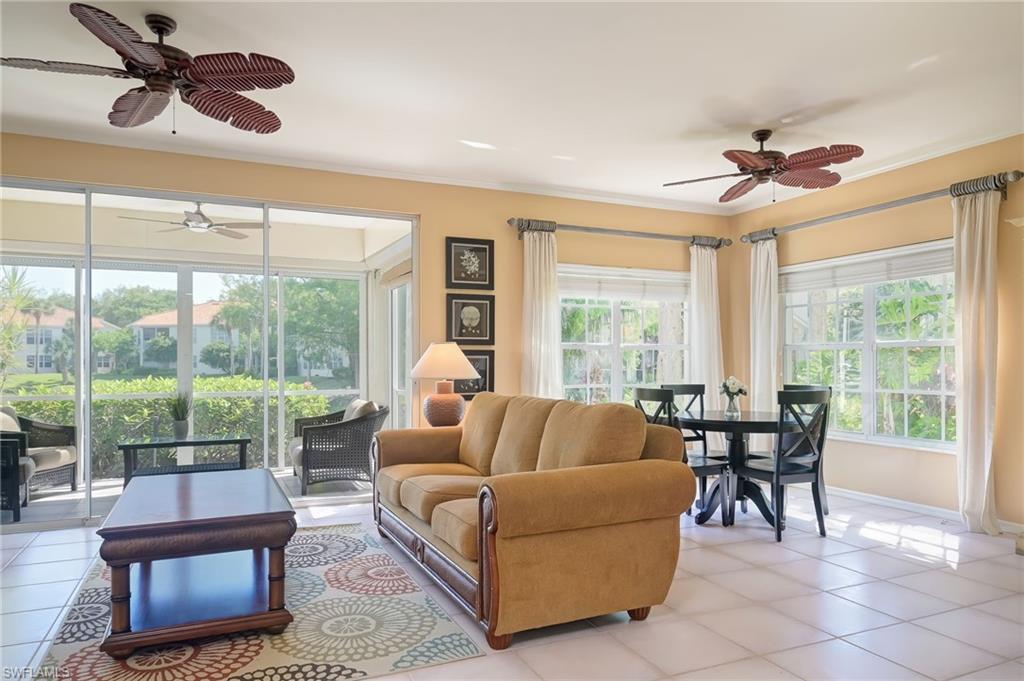 1072 Egrets Walk Circle, Unit 104 Naples, FL 34108 - Photo 11 of 37 a living room with furniture and a large window