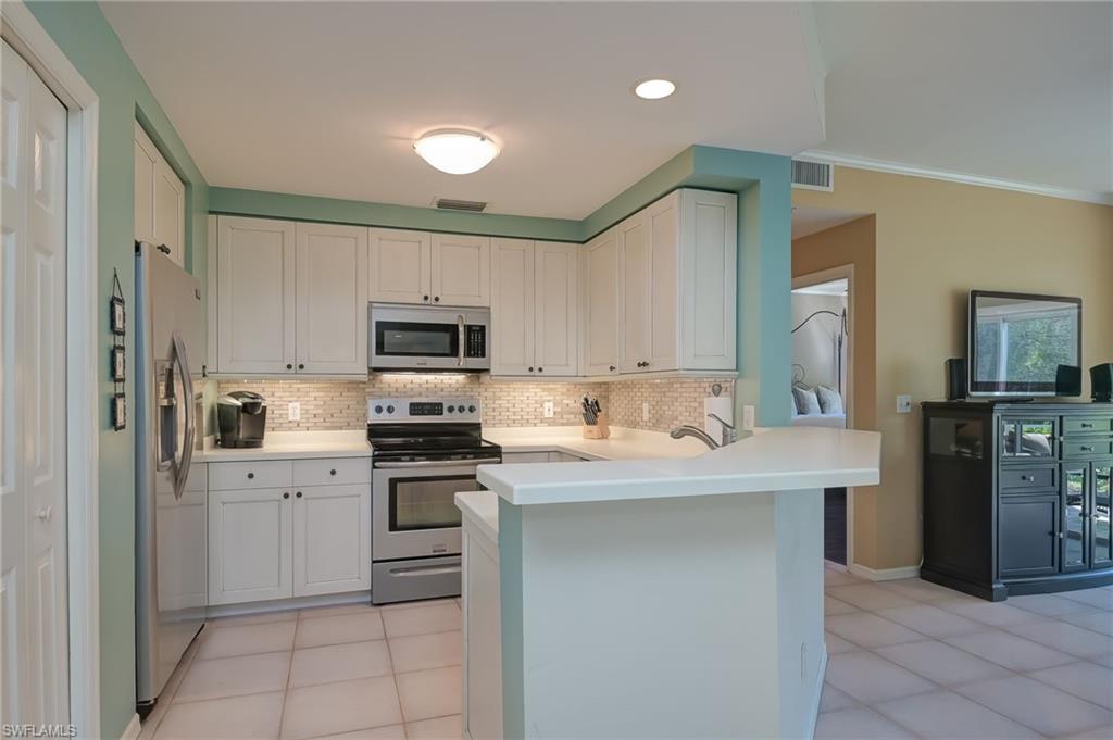 1072 Egrets Walk Circle, Unit 104 Naples, FL 34108 - Photo 12 of 37 a kitchen with a sink stove and refrigerator