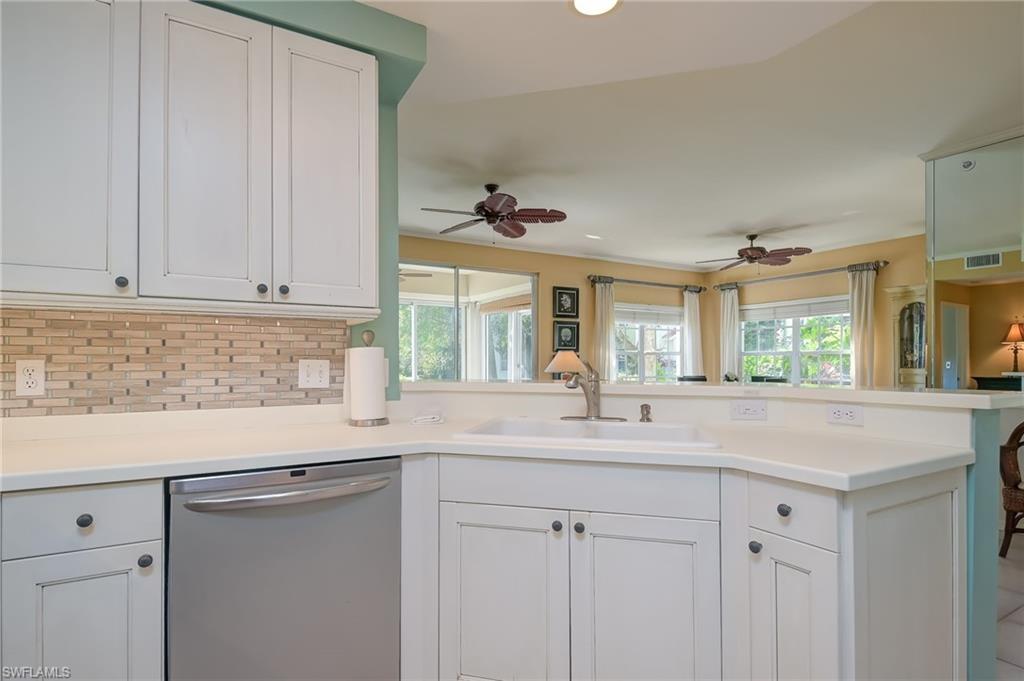 1072 Egrets Walk Circle, Unit 104 Naples, FL 34108 - Photo 14 of 37 a kitchen with granite countertop white cabinets and a sink