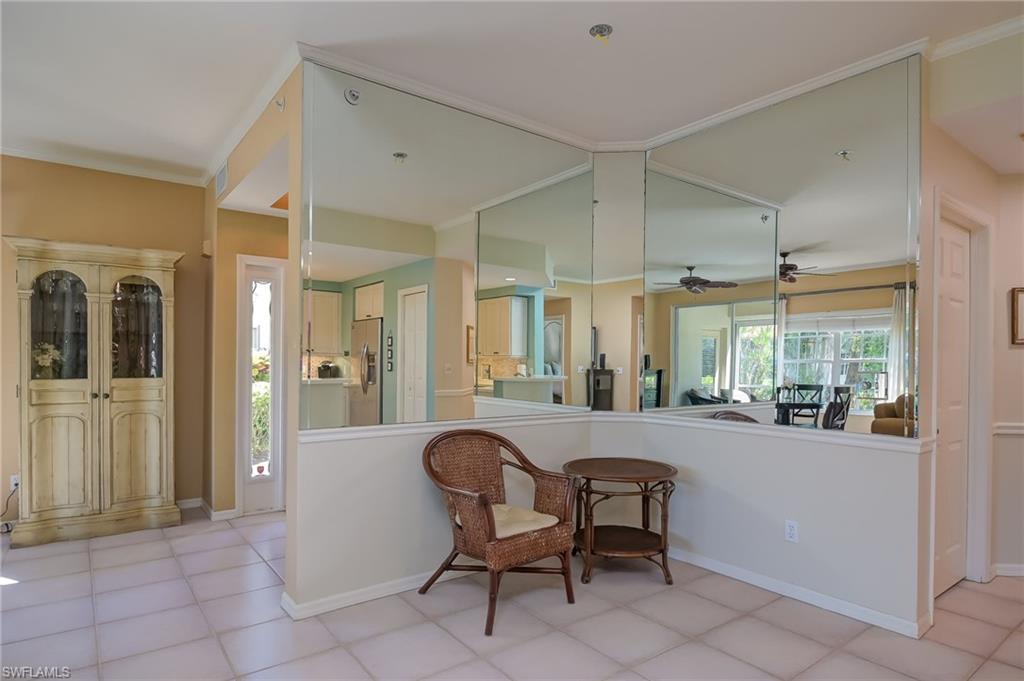 1072 Egrets Walk Circle, Unit 104 Naples, FL 34108 - Photo 15 of 37 a living room with furniture and a large window