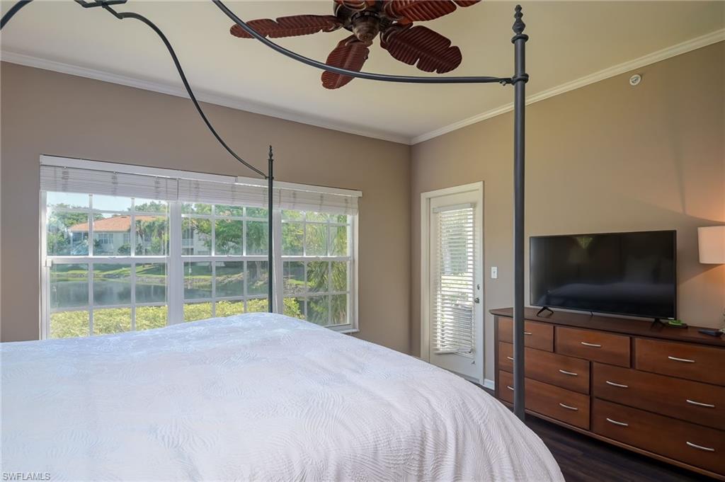 1072 Egrets Walk Circle, Unit 104 Naples, FL 34108 - Photo 17 of 37 a bedroom with a bed and a flat screen tv