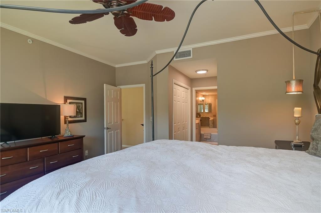 1072 Egrets Walk Circle, Unit 104 Naples, FL 34108 - Photo 18 of 37 a bedroom with a bed and a flat screen tv