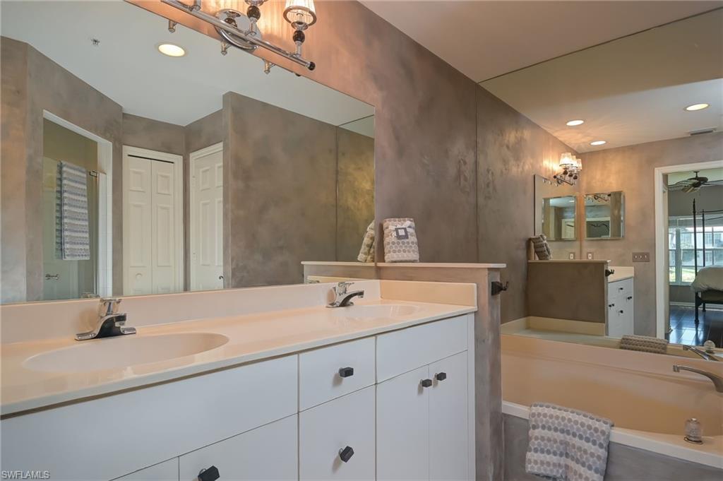 1072 Egrets Walk Circle, Unit 104 Naples, FL 34108 - Photo 19 of 37 a bathroom with a sink double vanity and a mirror