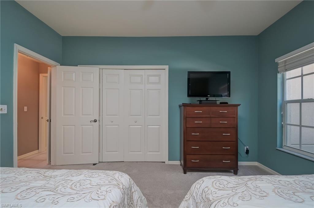 1072 Egrets Walk Circle, Unit 104 Naples, FL 34108 - Photo 25 of 37 a bedroom with a bed and a television