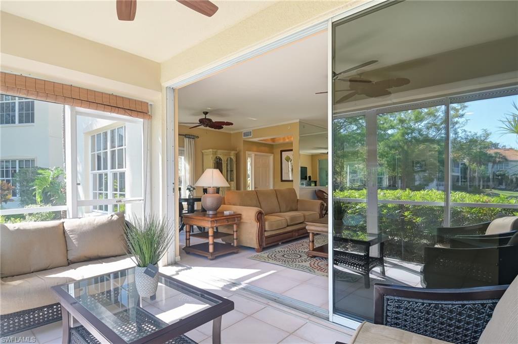 1072 Egrets Walk Circle, Unit 104 Naples, FL 34108 - Photo 26 of 37 a living room with furniture and a floor to ceiling window