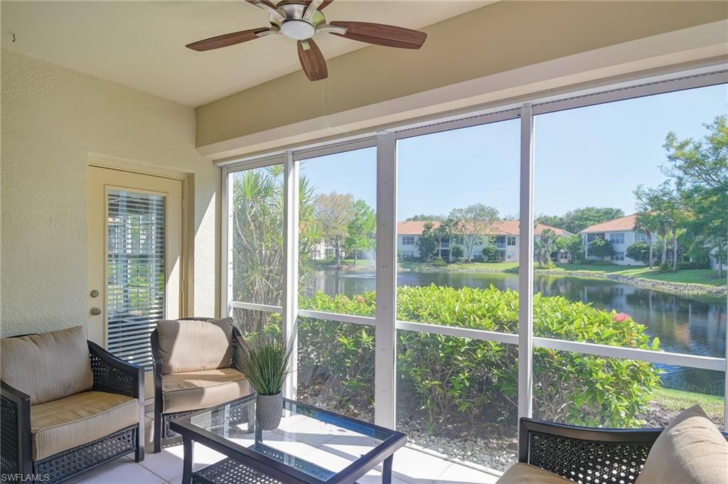 1072 Egrets Walk Circle, Unit 104 Naples, FL 34108 - Photo 28 of 37 a living room with hardwood floor and a floor to ceiling window
