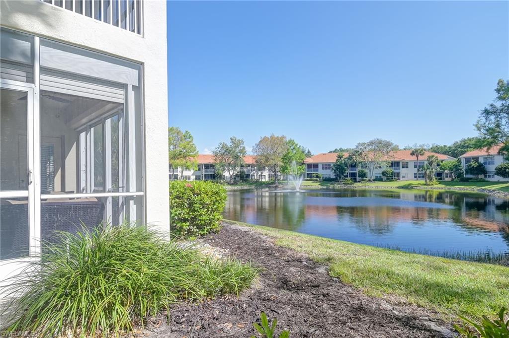 1072 Egrets Walk Circle, Unit 104 Naples, FL 34108 - Photo 29 of 37 a view of a lake with a building in the background