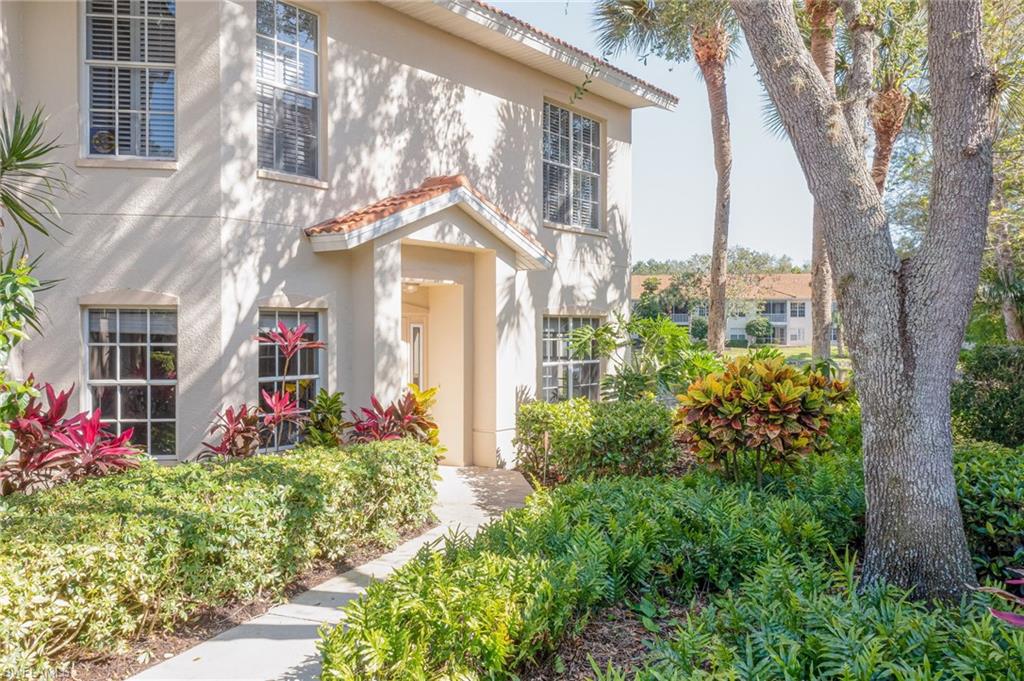 1072 Egrets Walk Circle, Unit 104 Naples, FL 34108 - Photo 3 of 37 a front view of a house with a yard
