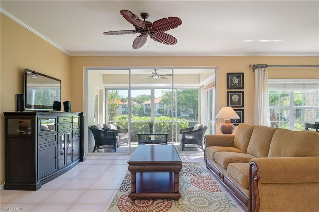 1072 Egrets Walk Circle, Unit 104 Naples, FL 34108 - Photo 5 of 37 a living room with furniture and a large window