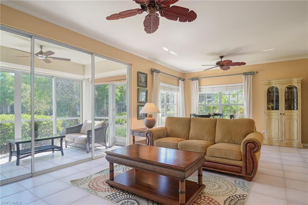 1072 Egrets Walk Circle, Unit 104 Naples, FL 34108 - Photo 7 of 37 a living room with furniture and a large window