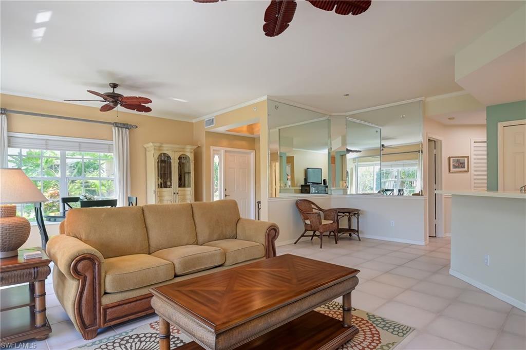 1072 Egrets Walk Circle, Unit 104 Naples, FL 34108 - Photo 8 of 37 a living room with furniture a ceiling fan and a window