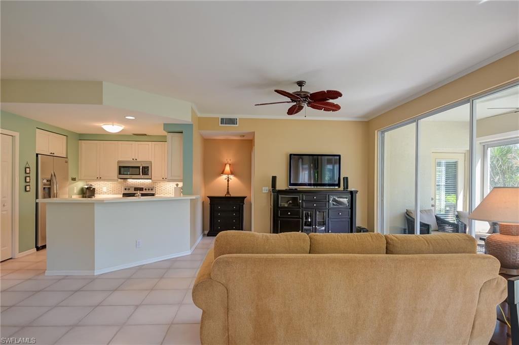 1072 Egrets Walk Circle, Unit 104 Naples, FL 34108 - Photo 10 of 37 a view of kitchen with microwave a refrigerator and a sink