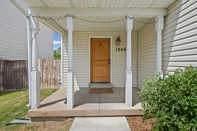 1346 Archmore Drive Springville, UT 84663 - Photo 22 of 32 Front porch entry featuring a wood-finish door, white siding, and decorative columns