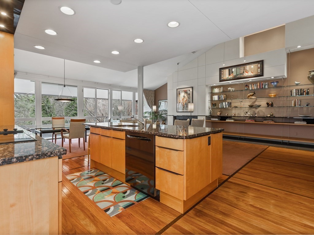 241 Perkins Street, Unit A602 Boston, MA 02130 - Photo 1 of 24 a kitchen with stainless steel appliances granite countertop a stove top oven a sink dishwasher a dining table and chairs with wooden floor