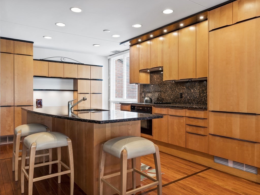 241 Perkins Street, Unit A602 Boston, MA 02130 - Photo 7 of 24 a kitchen with stainless steel appliances granite countertop a stove a sink and a refrigerator