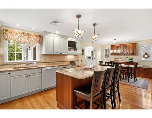 10 Hemlock Road Reading, MA 01867 - Photo 12 of 42 a open kitchen with stainless steel appliances granite countertop a stove a sink dishwasher a dining table and chairs with wooden floor