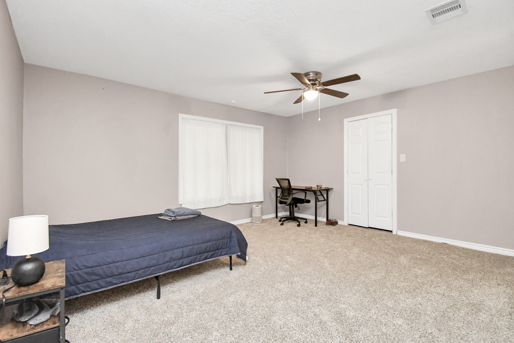 3743 Odin Court Houston, TX 77021 - Photo 26 of 36 Plush and peaceful. Soft carpeting underfoot creates an incredibly cozy ambiance in this spacious bedroom, featuring a broad window, ceiling fan, and closet space.