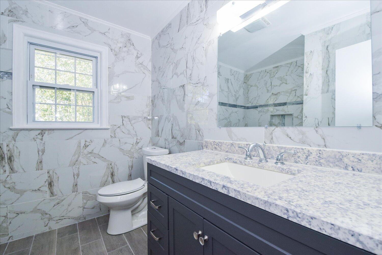3703 Cove Road Roanoke, VA 24017 - Photo 12 of 27 a bathroom with a granite countertop sink a toilet and mirror