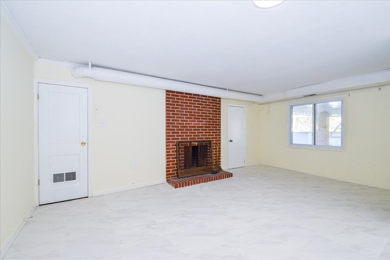 3703 Cove Road Roanoke, VA 24017 - Photo 19 of 27 a view of an empty room with a fireplace and a window