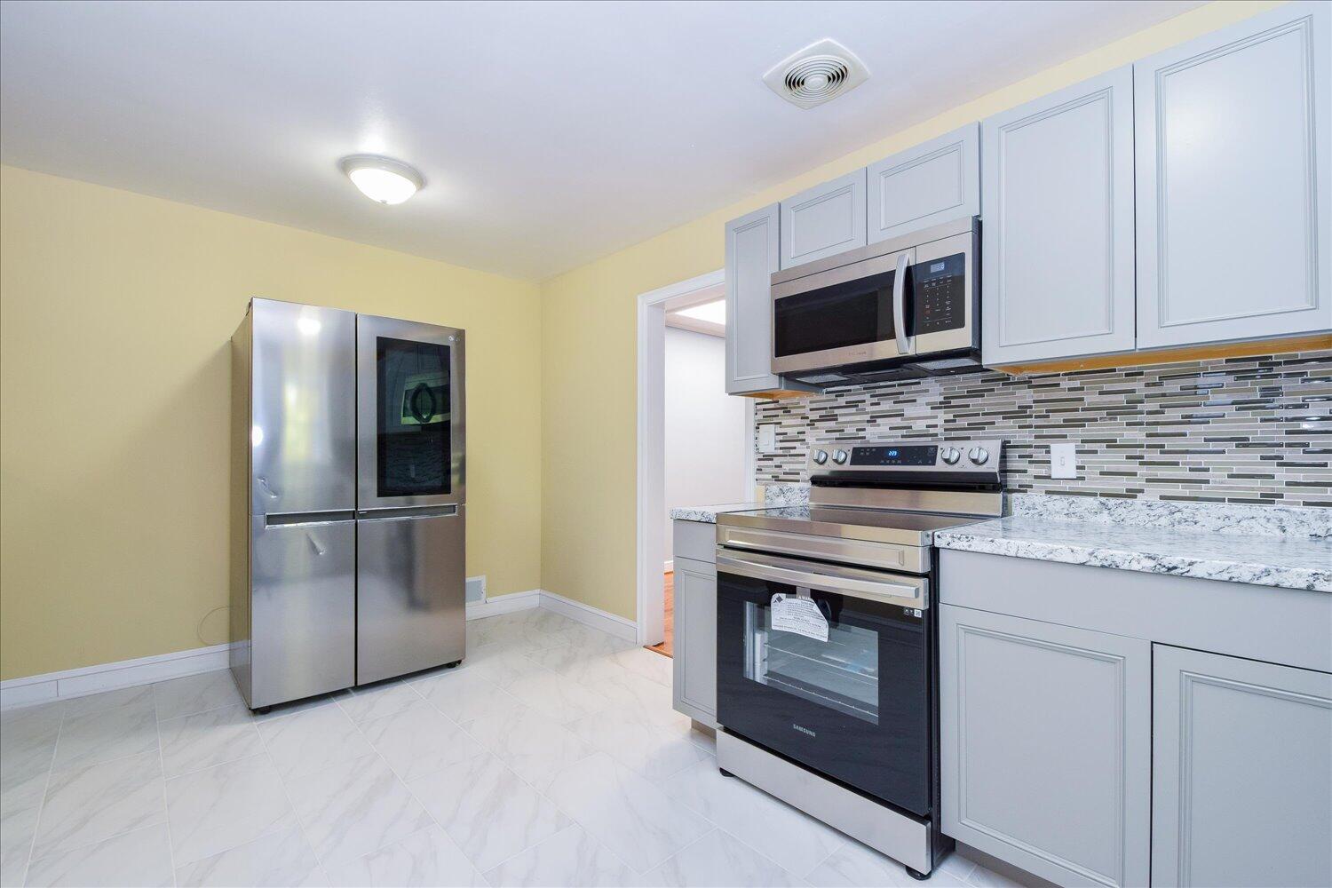 3703 Cove Road Roanoke, VA 24017 - Photo 4 of 27 a kitchen with stainless steel appliances granite countertop a stove a refrigerator and a microwave
