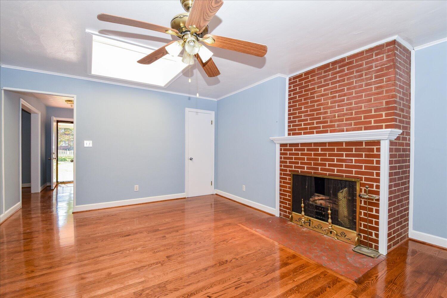 3703 Cove Road Roanoke, VA 24017 - Photo 5 of 27 a view of an empty room with wooden floor fireplace and a window