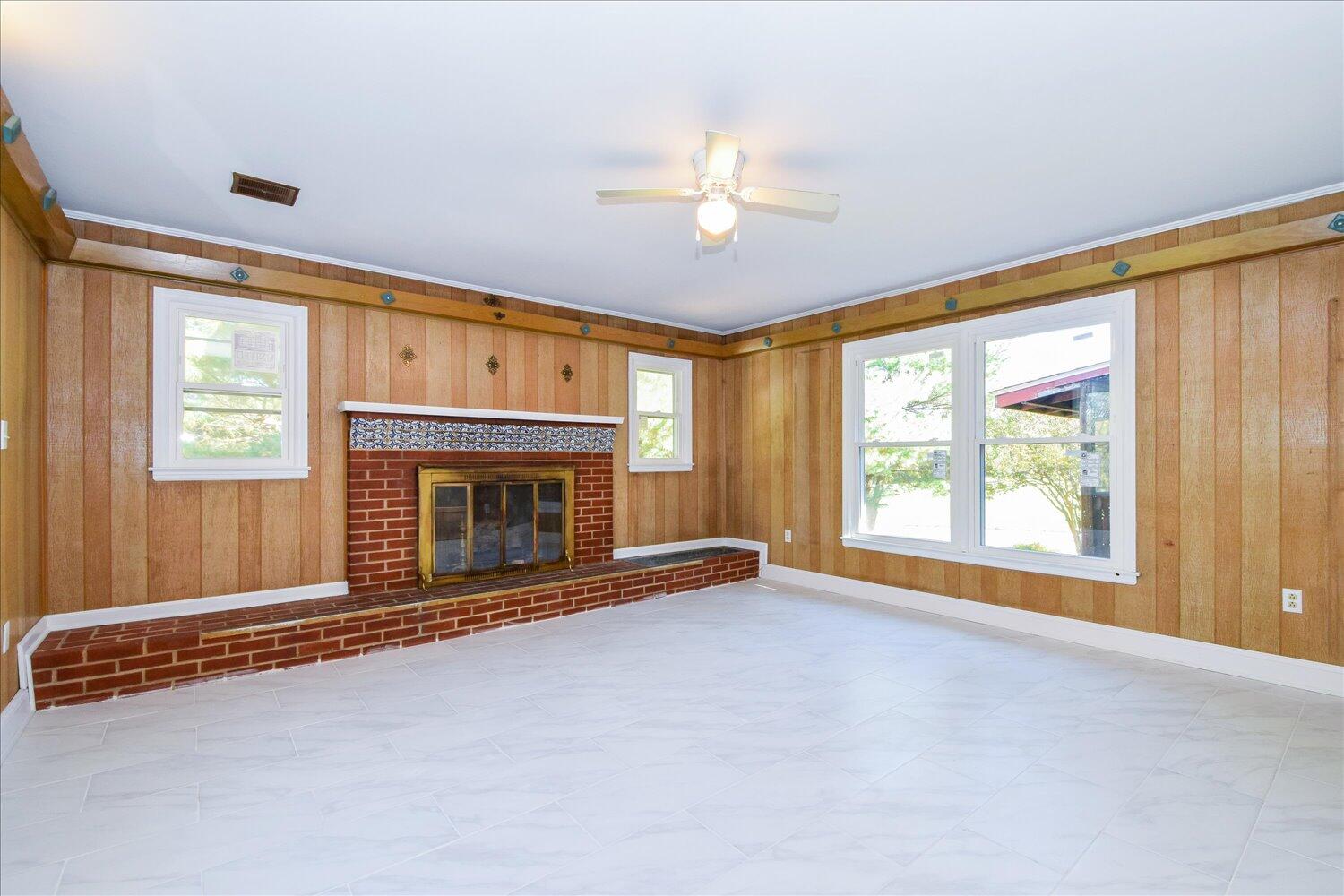 3703 Cove Road Roanoke, VA 24017 - Photo 6 of 27 a view of an empty room with a fireplace and a window