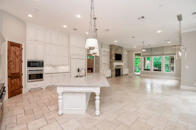 a large kitchen with a large counter top appliances and cabinets