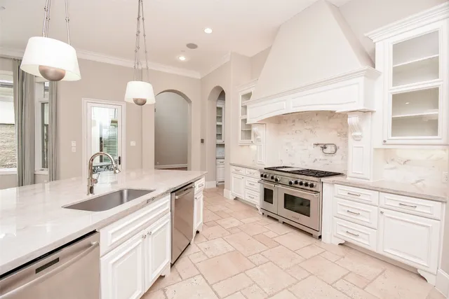 a kitchen with stainless steel appliances granite countertop a stove a sink and a refrigerator