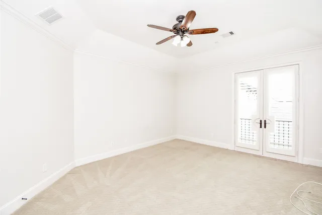 an empty room with a window and a ceiling fan