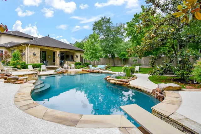 a view of a swimming pool with lounge chairs in patio