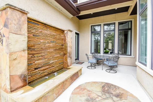 a view of a patio with a dining table and chairs with wooden floor and plants