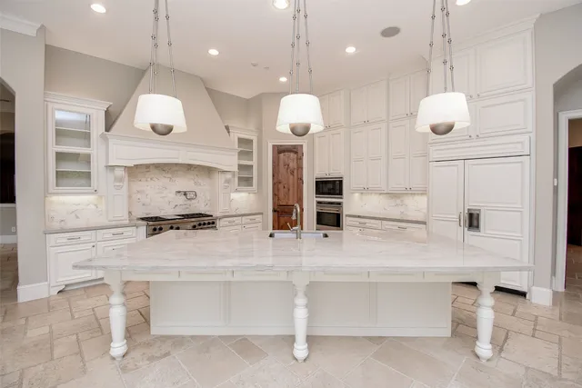 a large white kitchen with lots of counter space and appliances