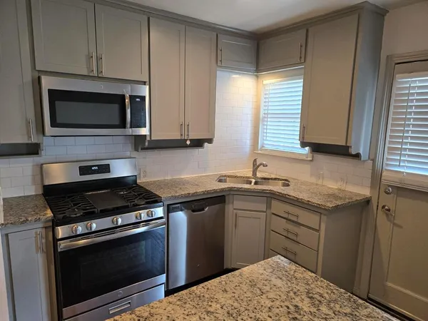 a kitchen with a sink stove and microwave