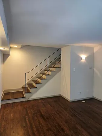 a view of an empty room with wooden floor