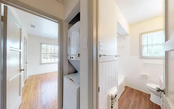 a view of hallway with bathroom and wooden floor